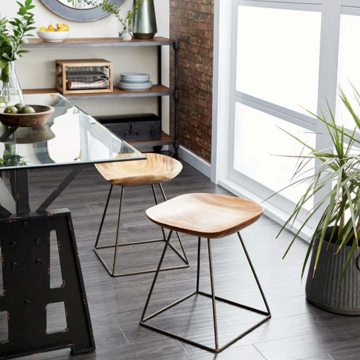 two wooden dining stools at a glass table