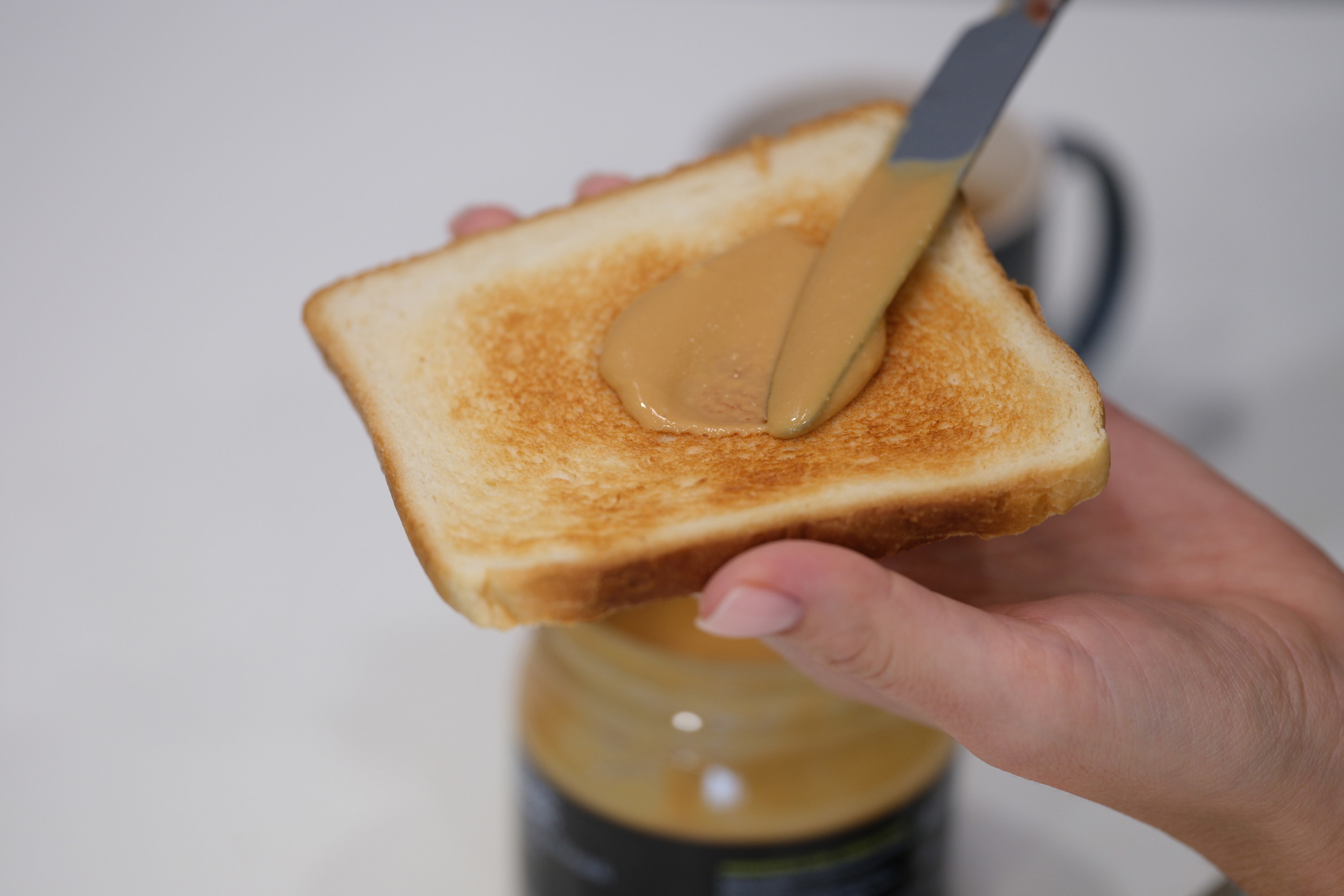 peanut butter being spread on a piece of toast