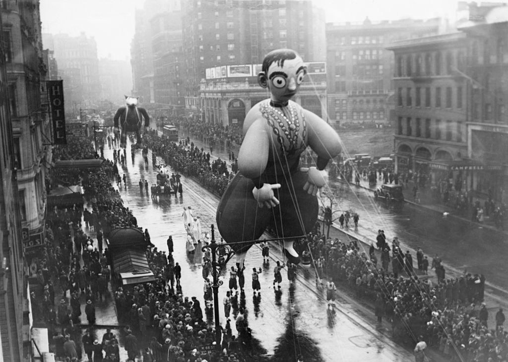 an old photograph of the parade with large ballons