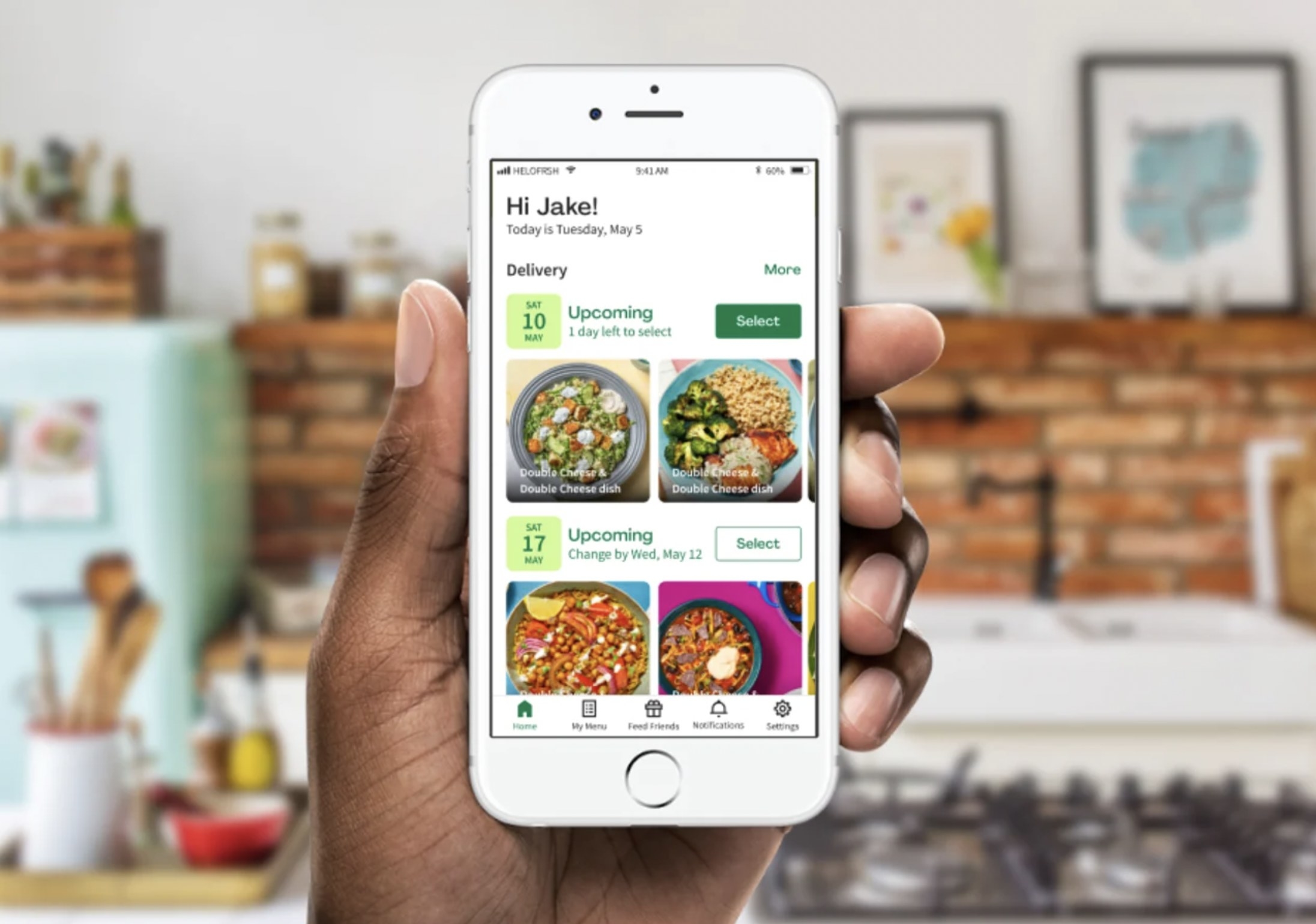 Someone holding smartphone with app open showing upcoming deliveries and recipes
