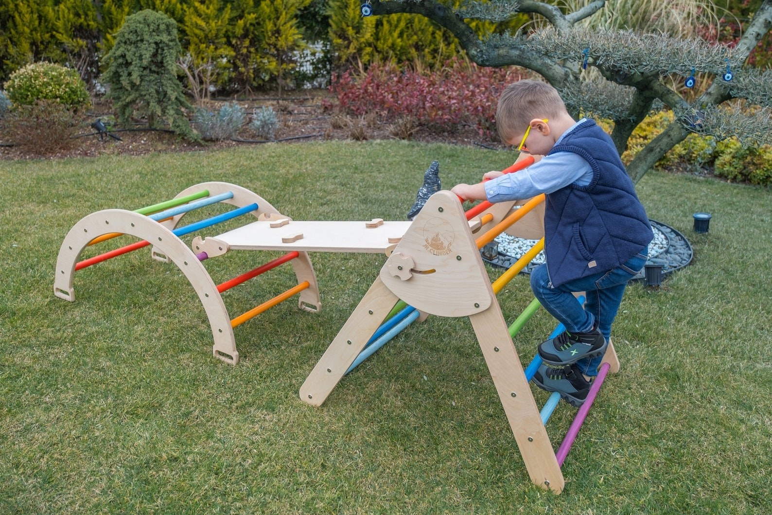 Two kids climbing the wooden triangle and ladder set