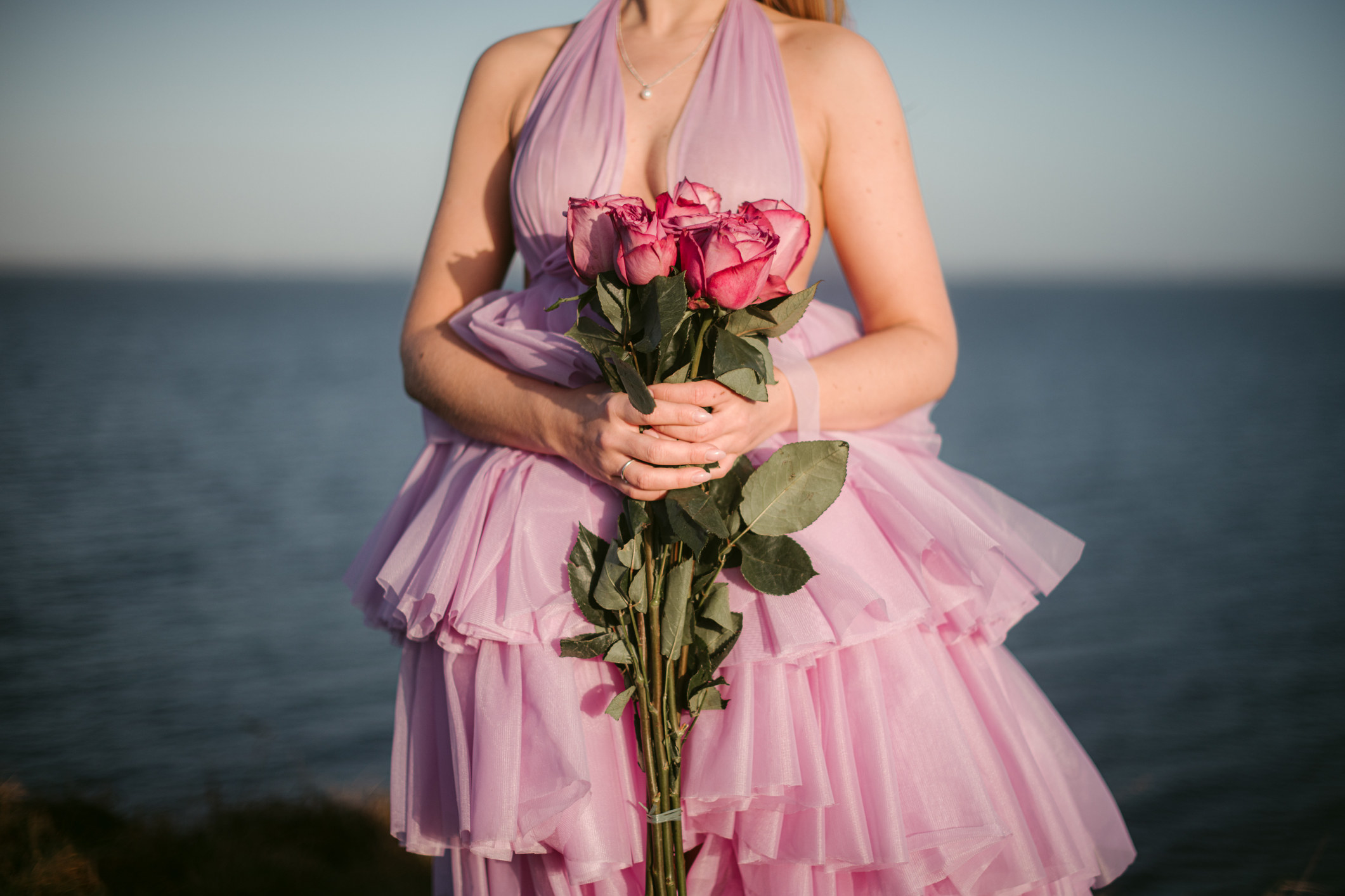 person wearing a blush wedding dress and holding flowers