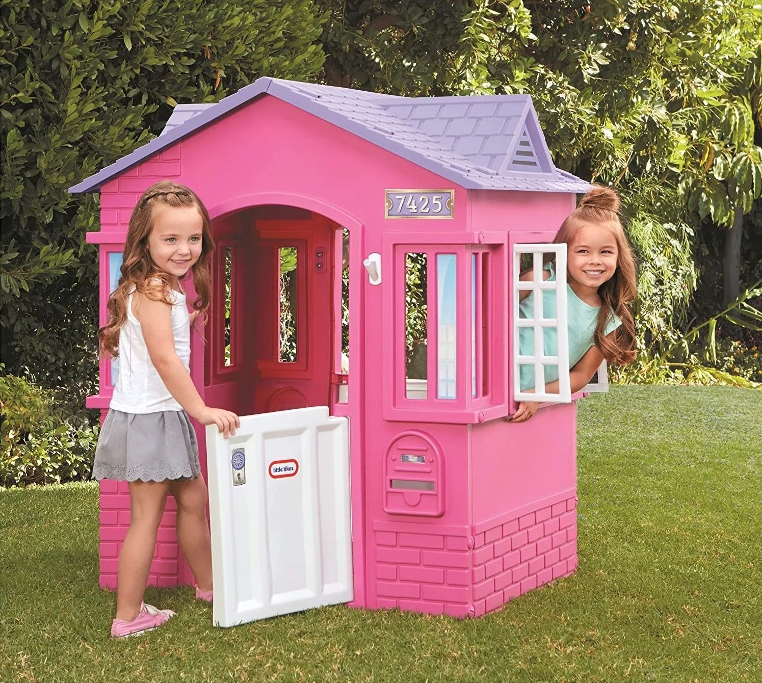 Two children playing with the pink playhouse