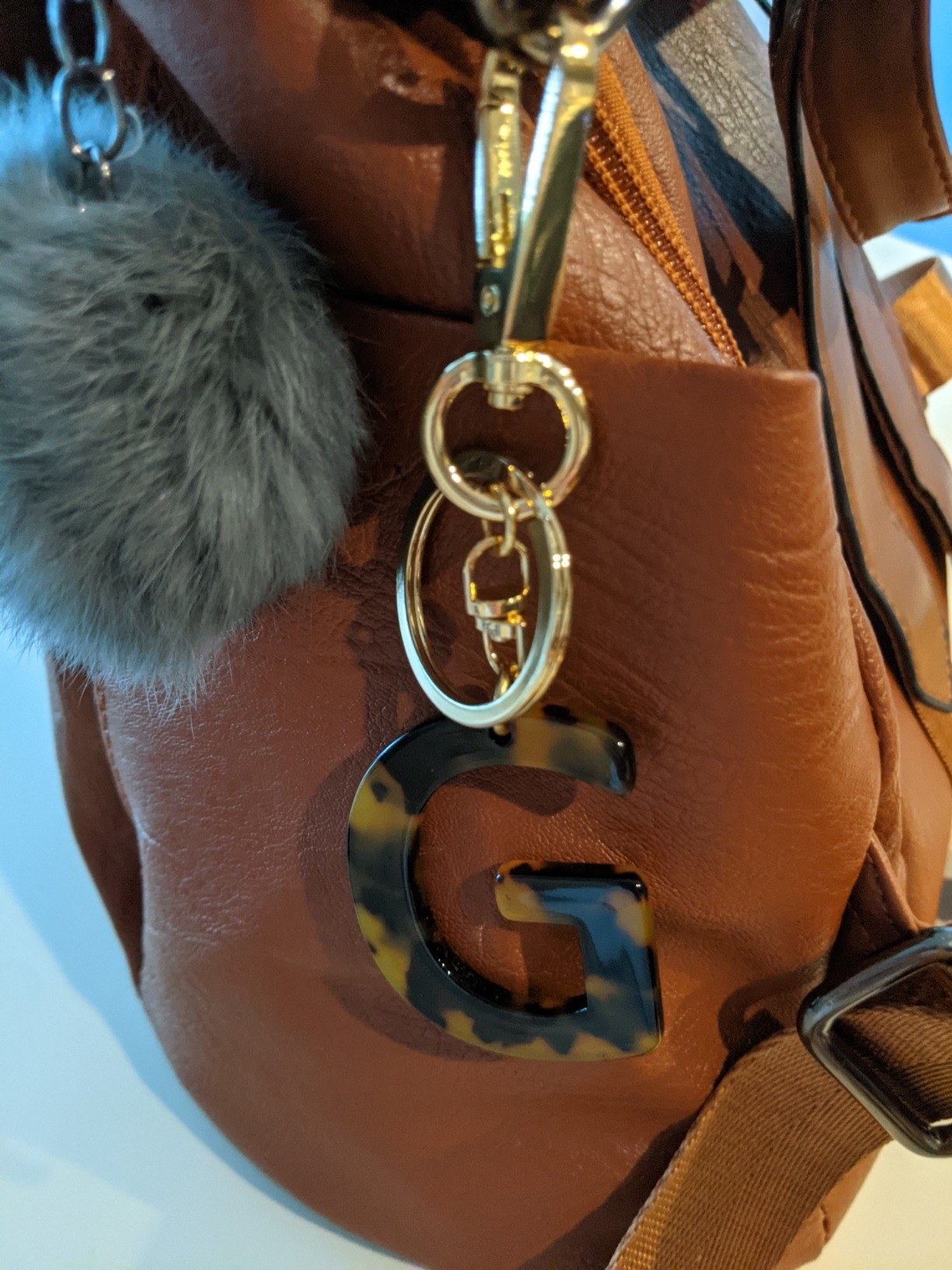 Reviewer image of &quot;G&quot; letter keychain on a brown leather bag