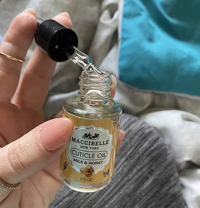 Reviewer holding bottle of cuticle oil