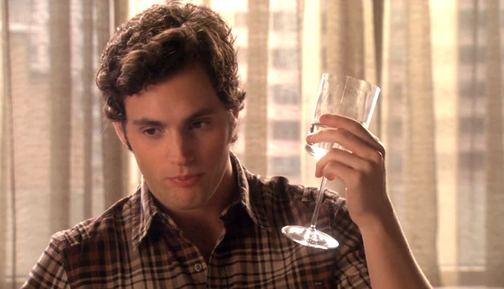 man holding a champagne glass looking lost in thought