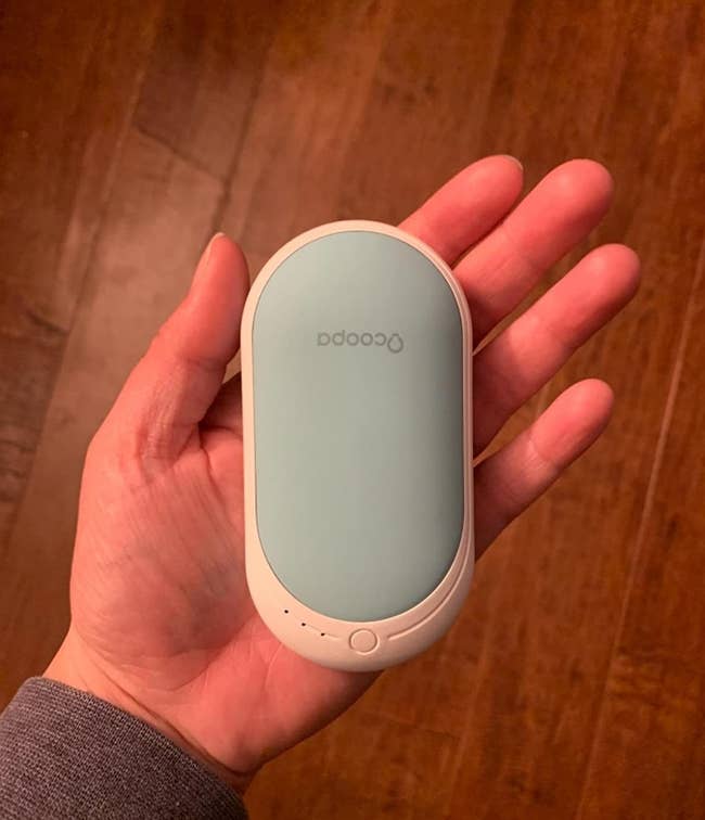 Reviewer holding rechargeable hand warmer