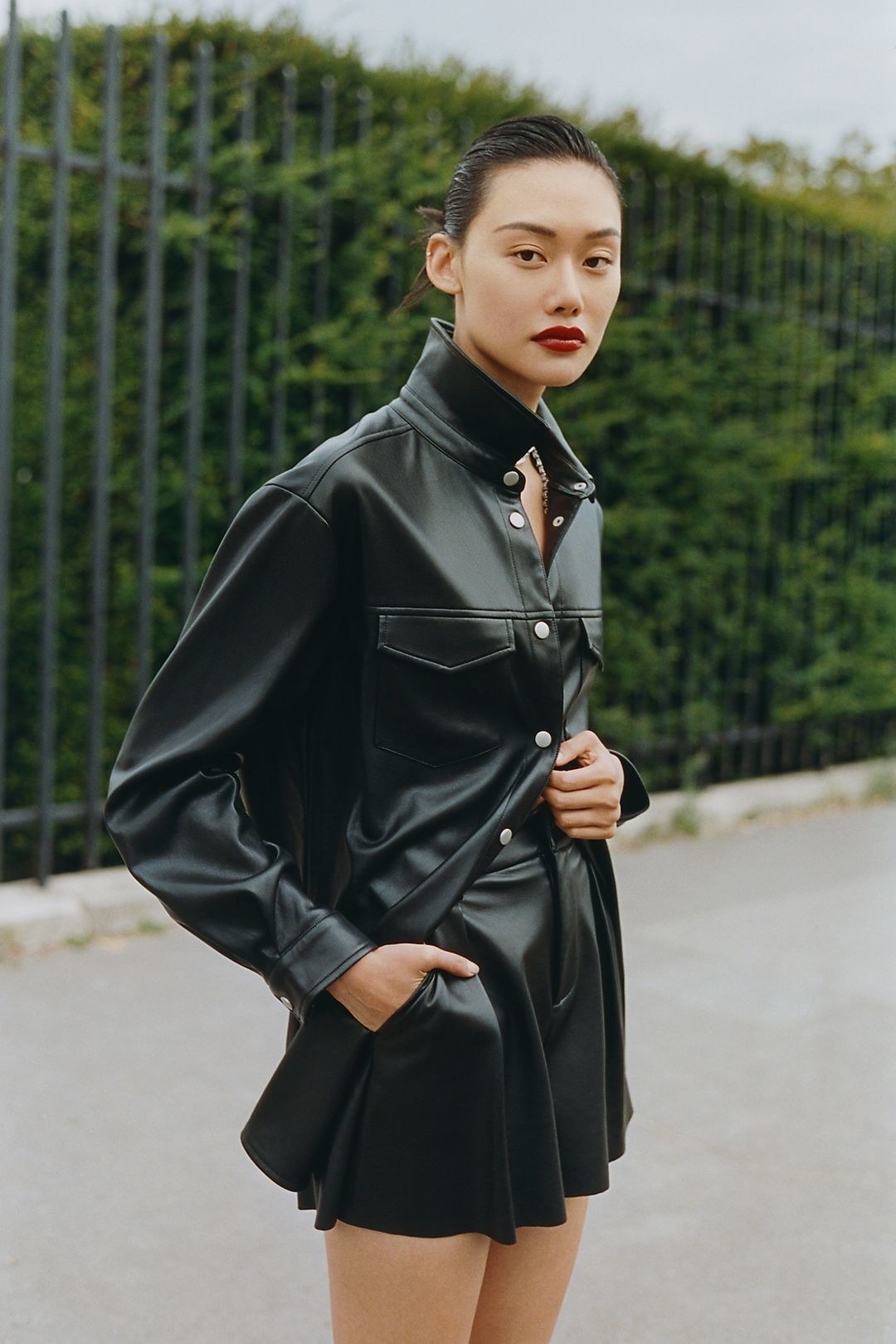 model in an oversized faux leather black button-up shirt jacket
