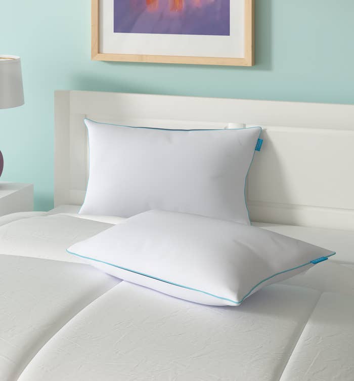 two of the white pillows on a bed