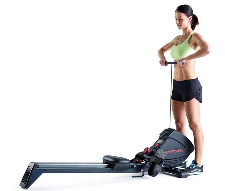 Someone standing next to a rowing machine
