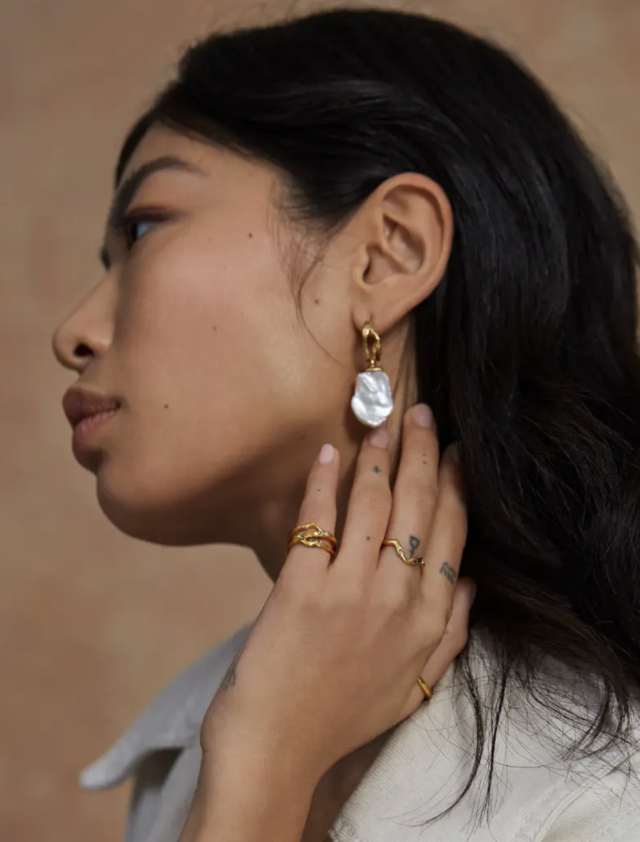 a person wearing the organic shaped pearl earrings