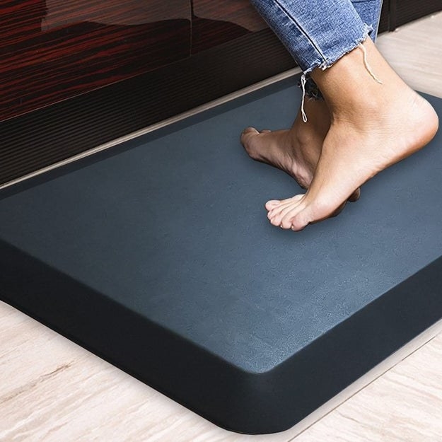 a person standing on the anti-fatigue mat