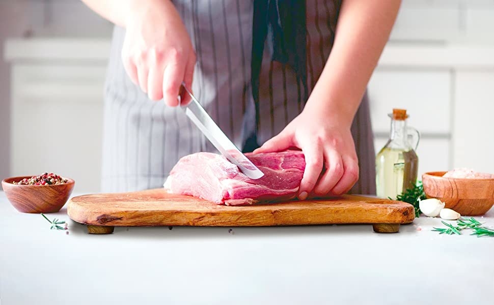 model cutting meat on a wooden chopping board
