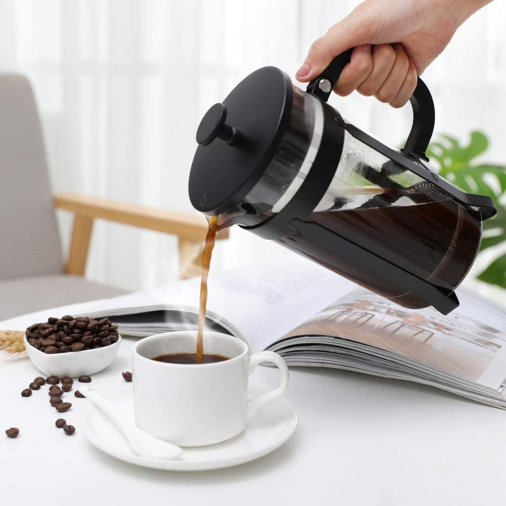 a person pouring coffee out of a french press