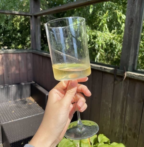 alice holding a wine glass outdoors