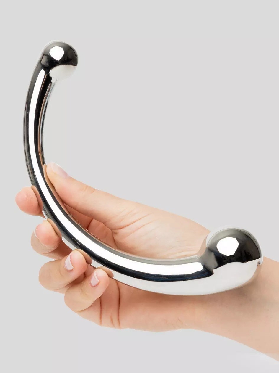 person holding the curved stainless steel dildo