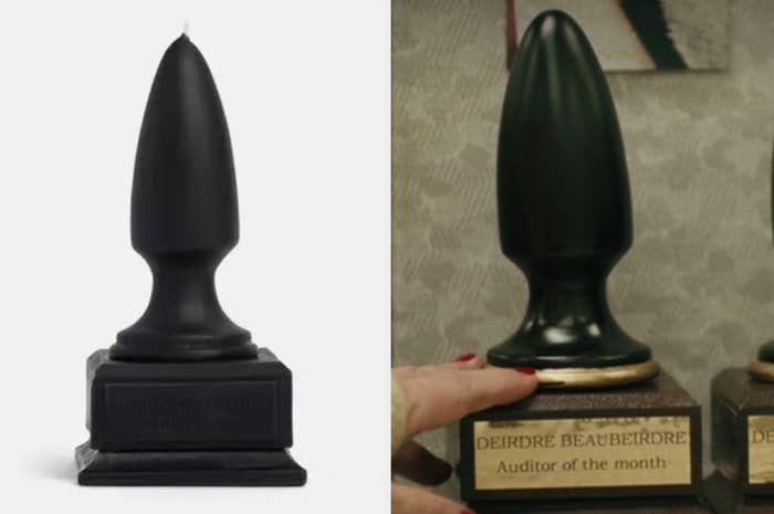 A large candle that's shaped like a butt plug, and the same shape award from the movie with a plaque that reads deirdre beaubeirdre auditor of the month