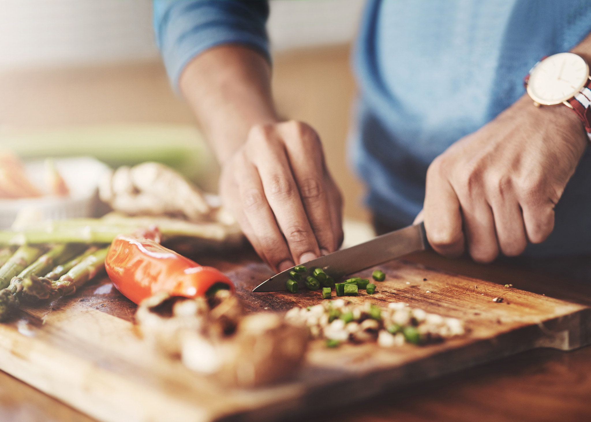 Person chops green onion in the kitchen