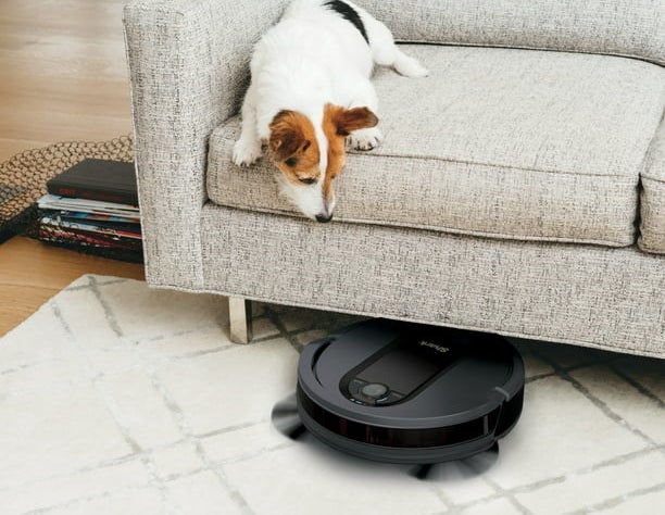 a robot vacuum cleaning under a couch