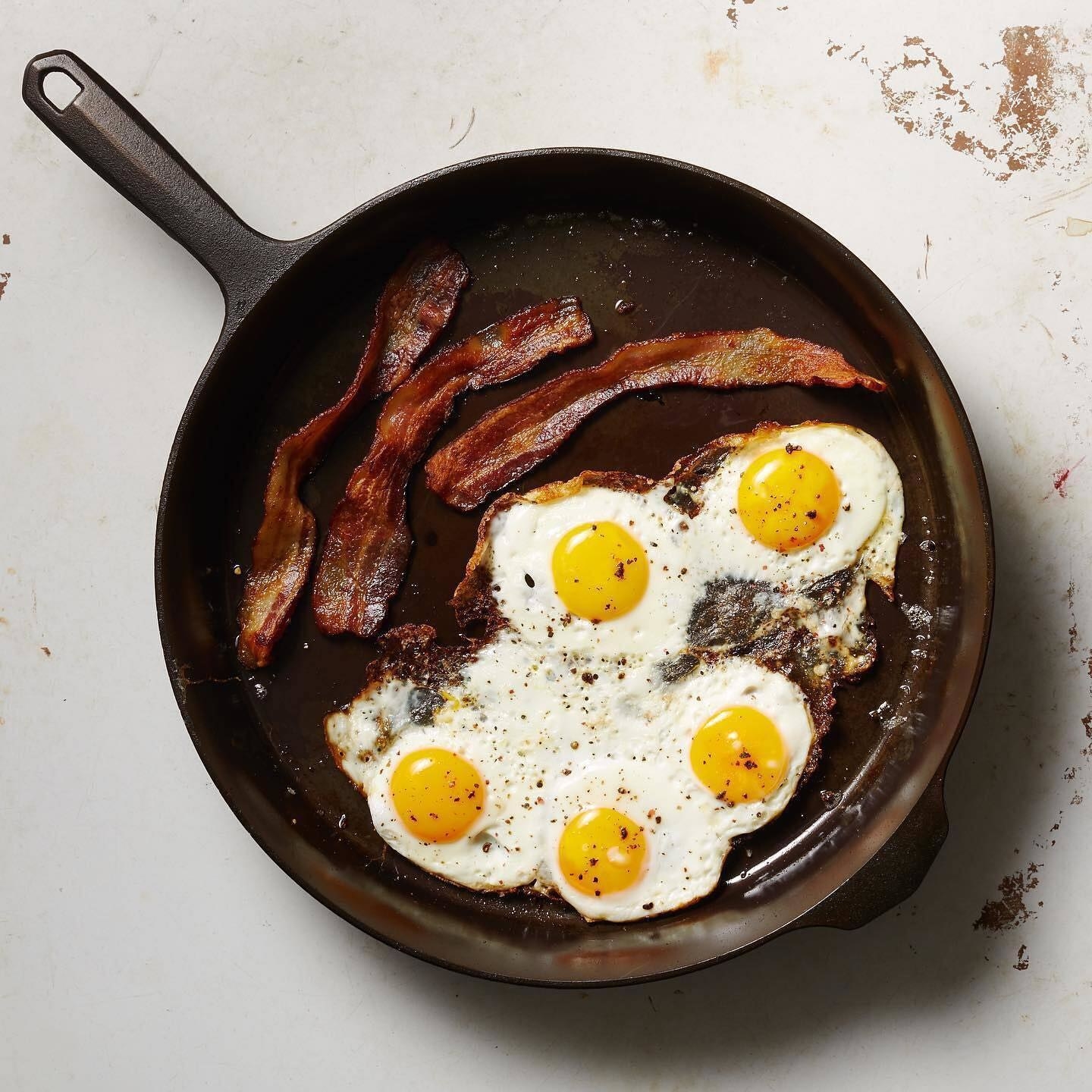 bacon and sunny side up eggs in a cast-iron skillet