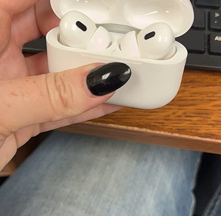 reviewer holding the AirPods