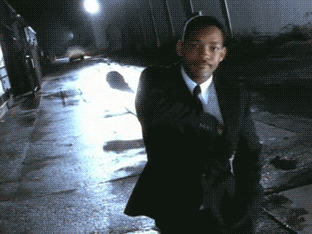 Will Smith in a suit uses a device to make you forget things