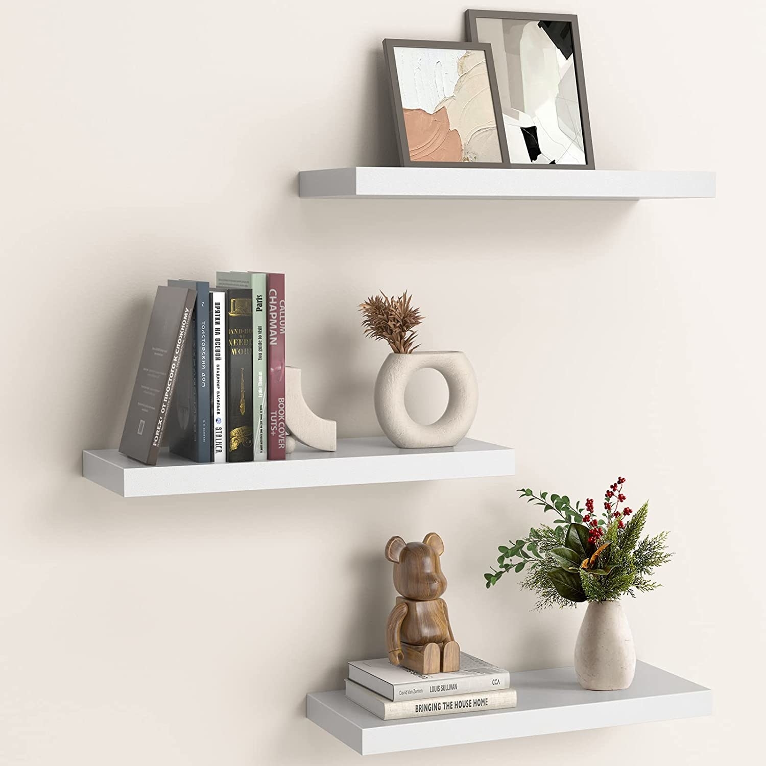 three shelves with books, plants, and other trinkets on them