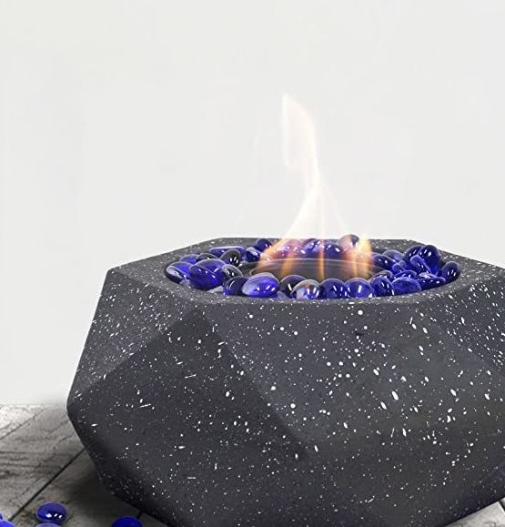 A picture of an indoor Fire pit that is lit and flames coming out of it