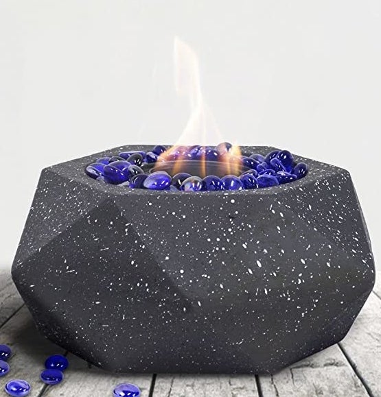 A picture of an indoor Fire pit that is lit and flames coming out of it