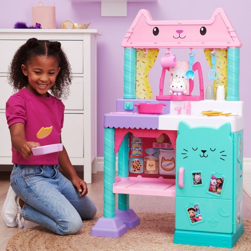 a child playing with the kitchen playset