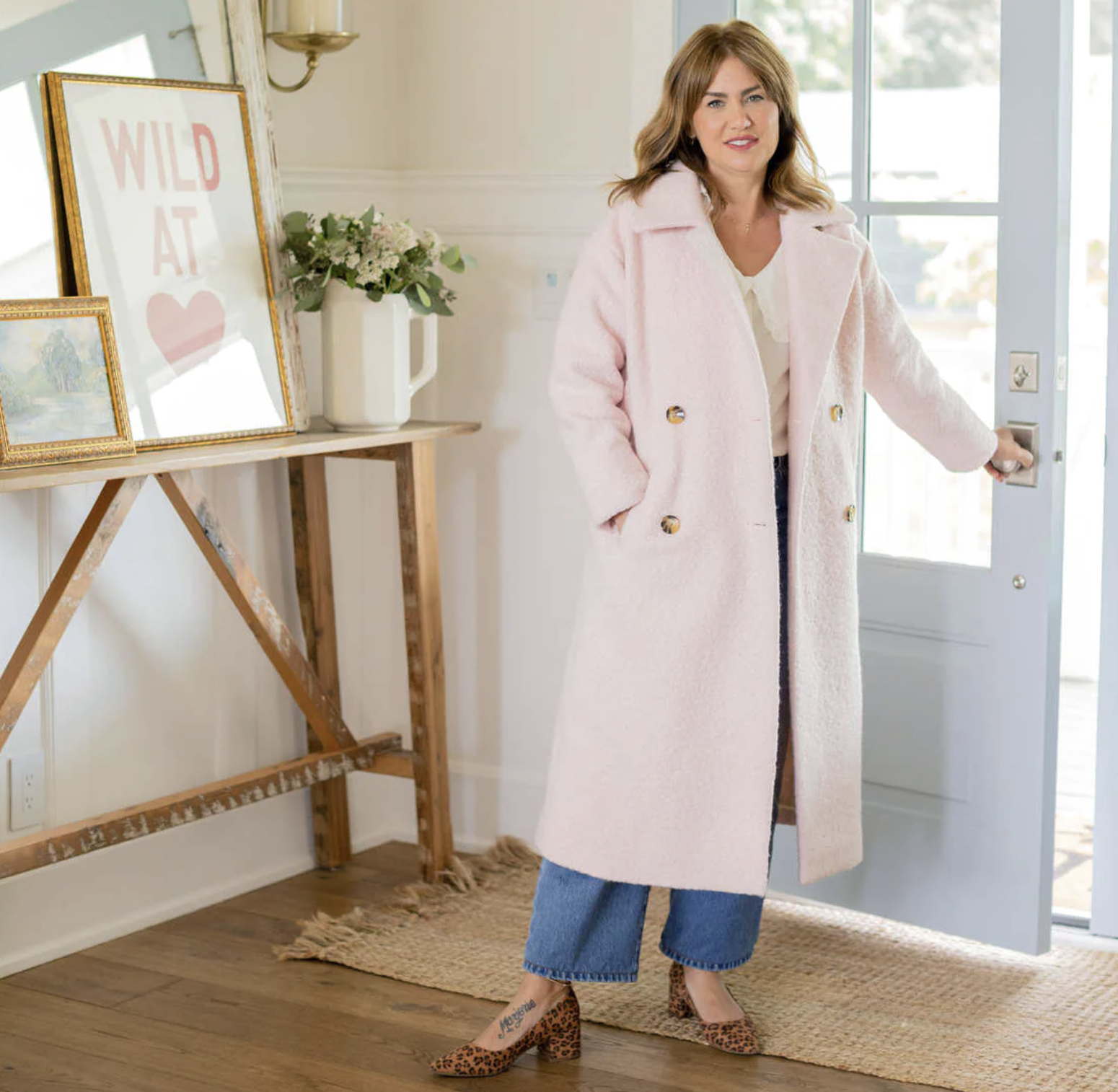 Jillian Harris wearing the coat while standing in an entryway and opening a front door