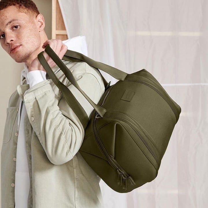 model with green duffel bag