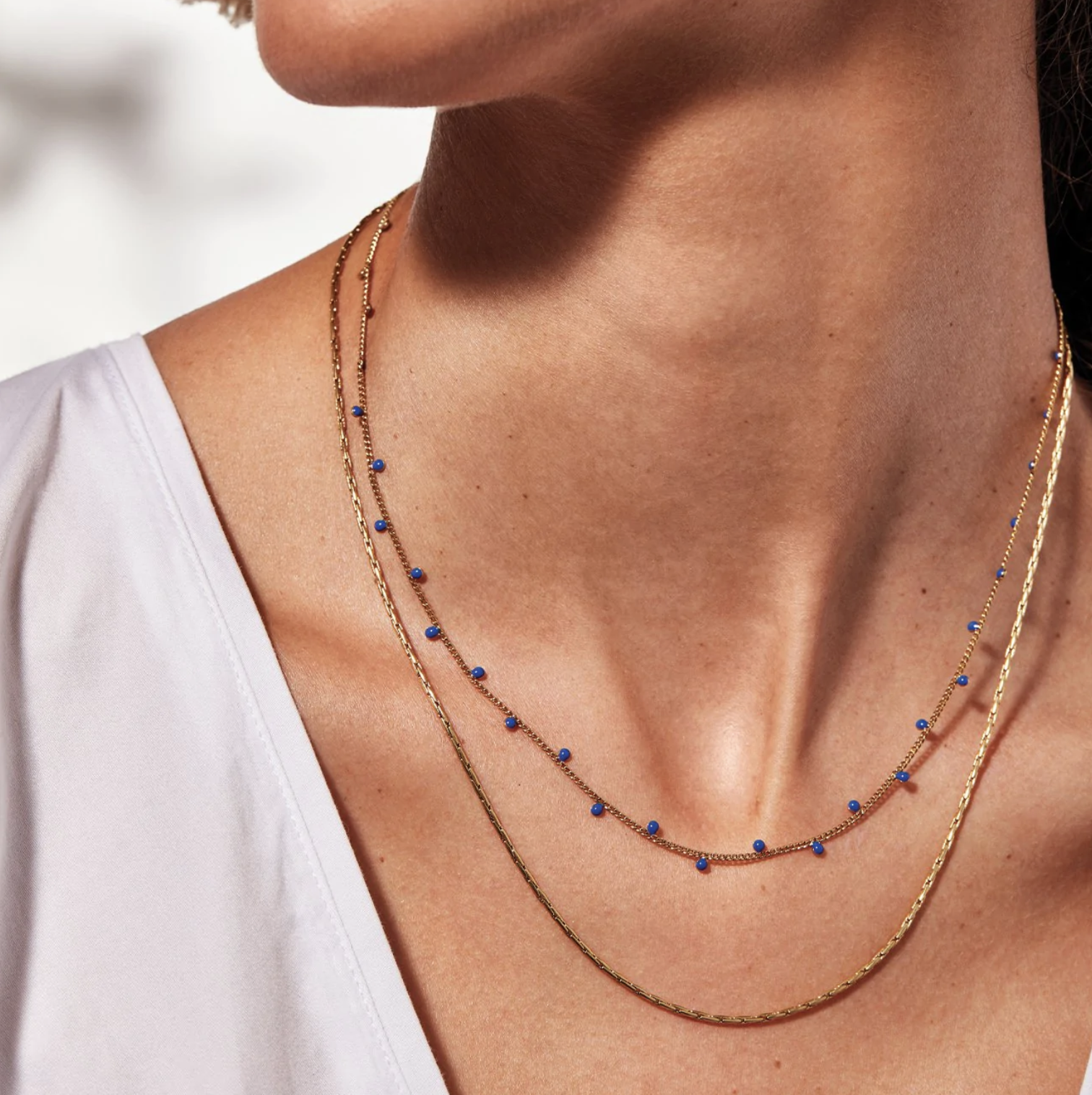 A person wearing the double-strand necklace with a V-neck top