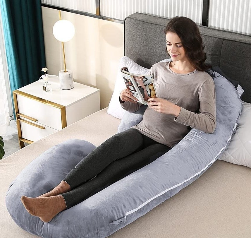 someone propped up reading while sitting in the pillow