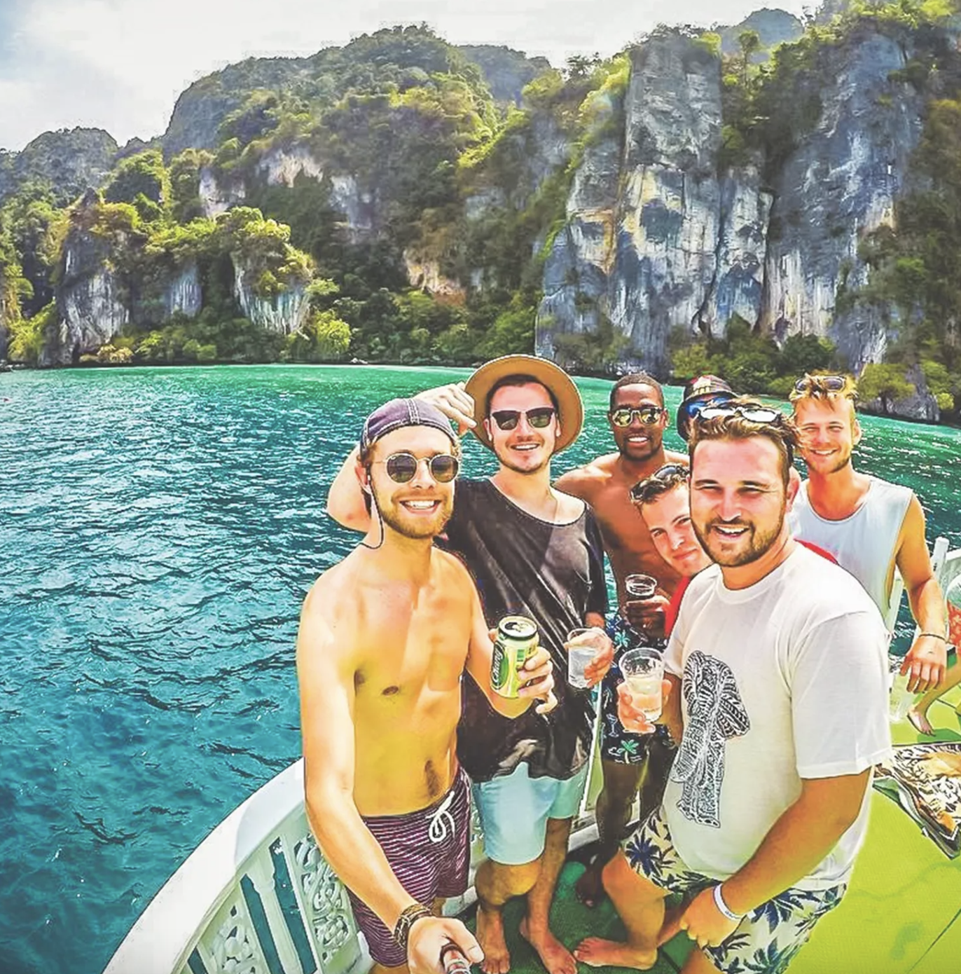 group of people on a boat with lush cliffs behind them