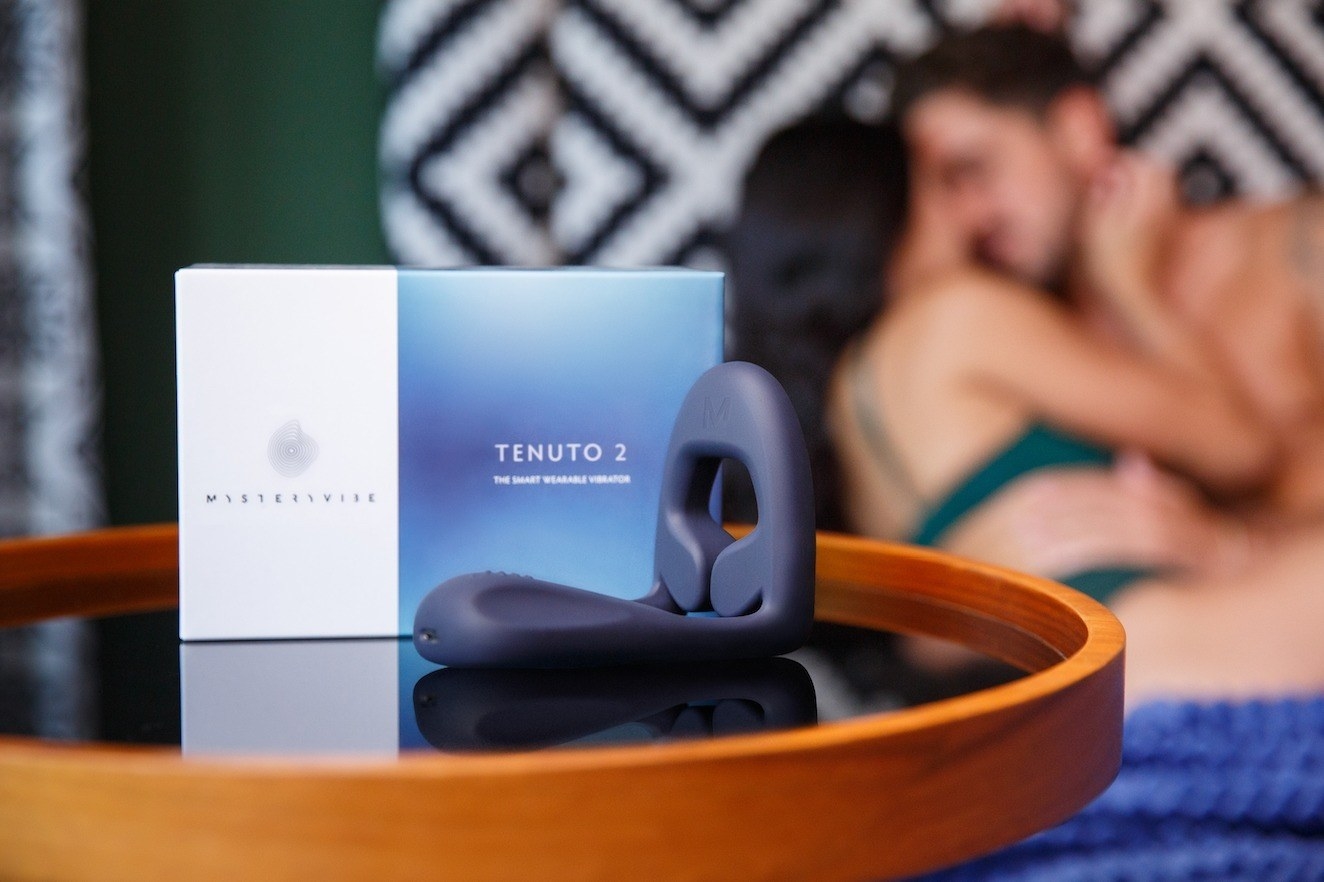 Blue cock ring next to box in front of couple on bed