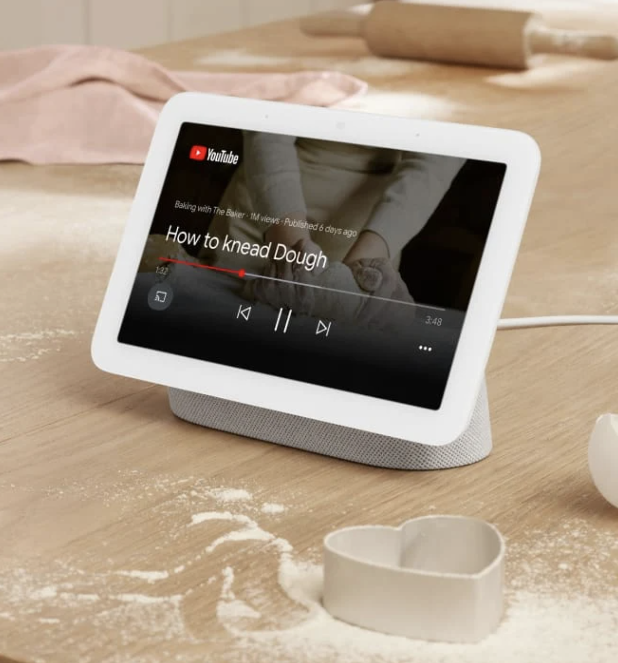 A Google hub on a counter surrounded by baked goods