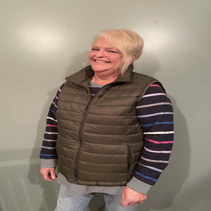 my aunt wearing the puffer jacket vest with a striped shirt and jeans