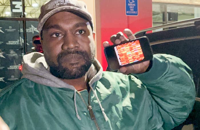 Ye holding a cellphone