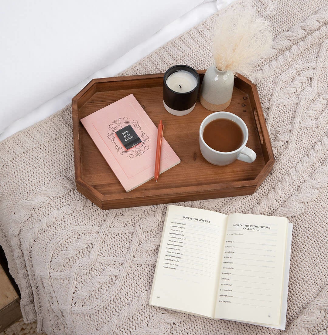 the book on a tray on top of a bed and another copy open on the bed