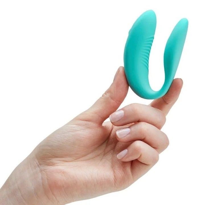 Hand holding aqua wearable vibrator