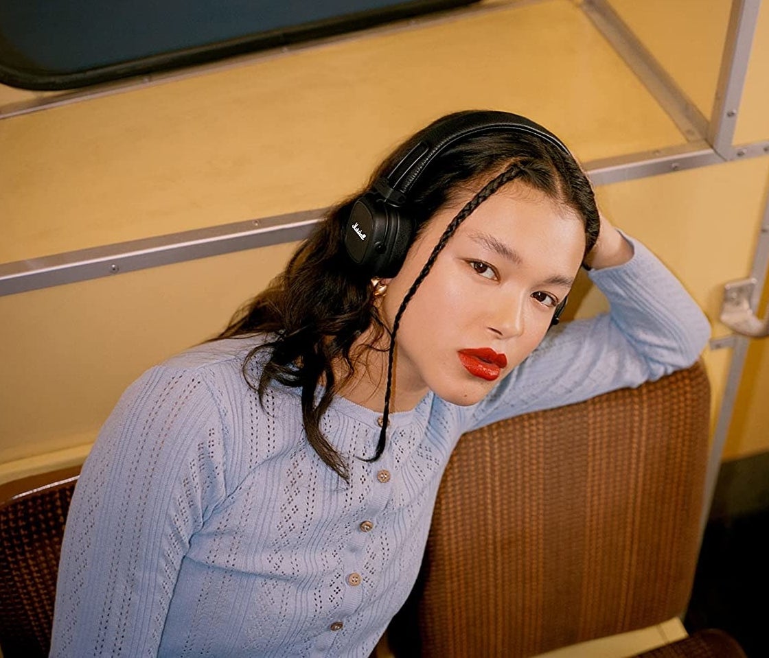 a model wearing the over ear headphones