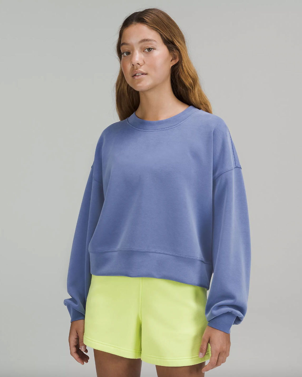 a person wearing the slouchy sweatshirt with a pair of shorts