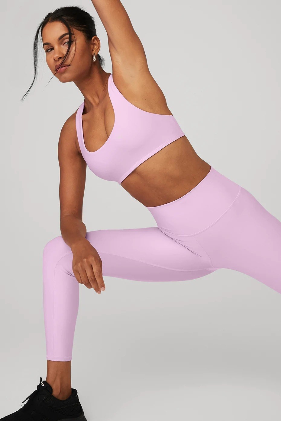model wearing matching pink sports bra and high-rise leggings