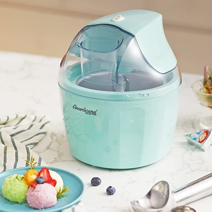 the ice cream maker on a counter next to a plate of ice cream