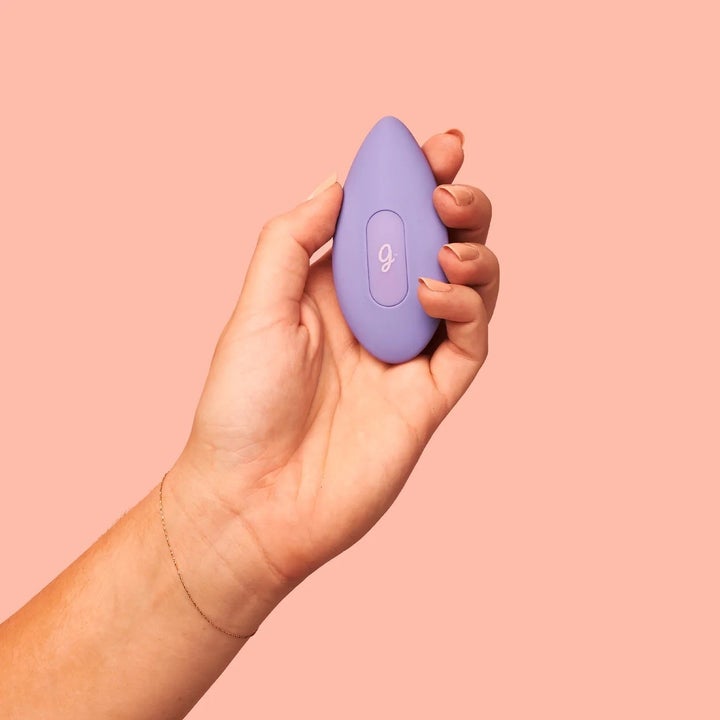 Hand holding purple palm-sized vibrator