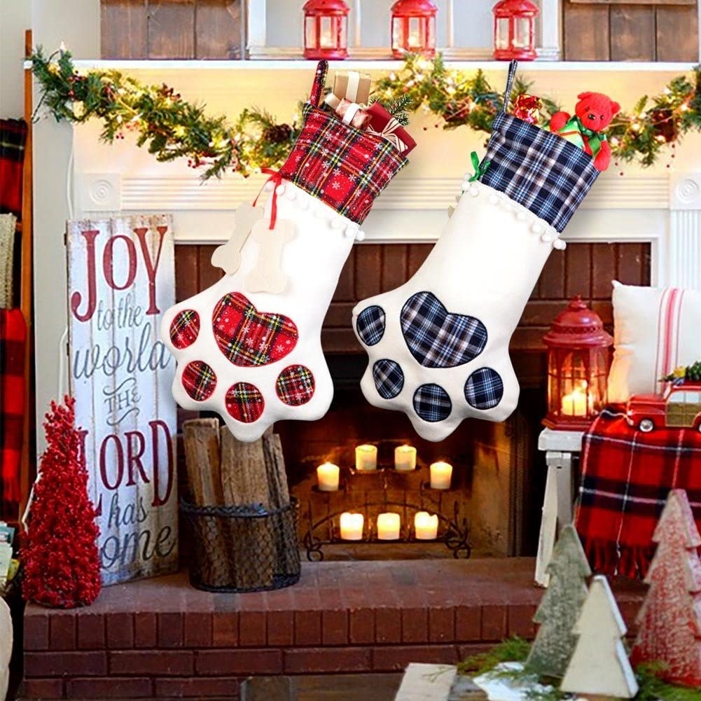 Two paw-shaped stockings hang from a mantel