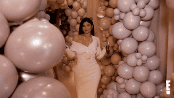 Kylie Jenner shimmying out of a room full of balloons