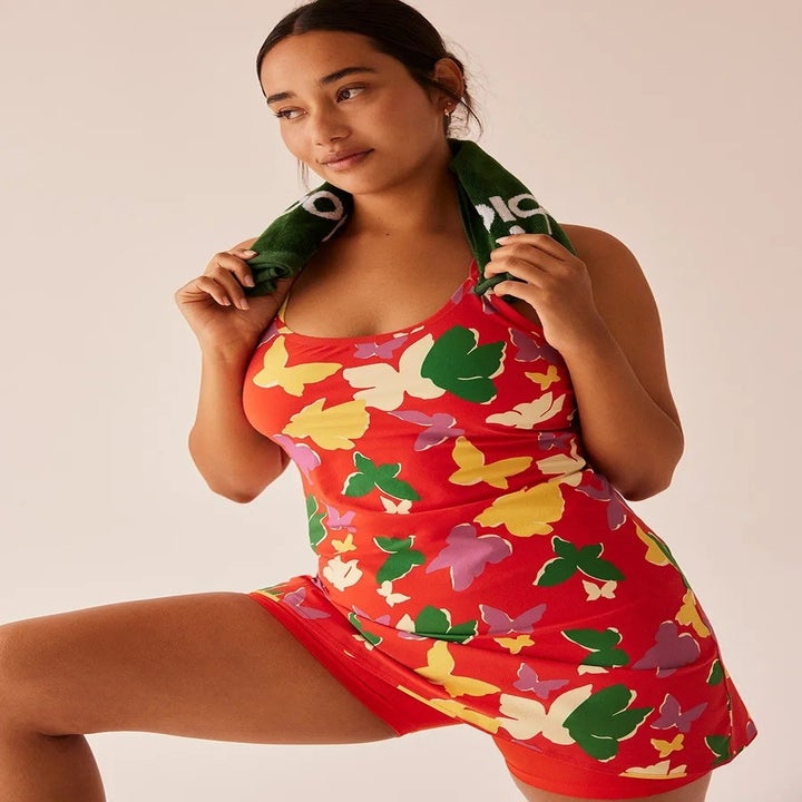 model wearing red butterfly-print sleeveless exercise dress