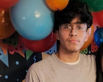 A youth with balloons behind him